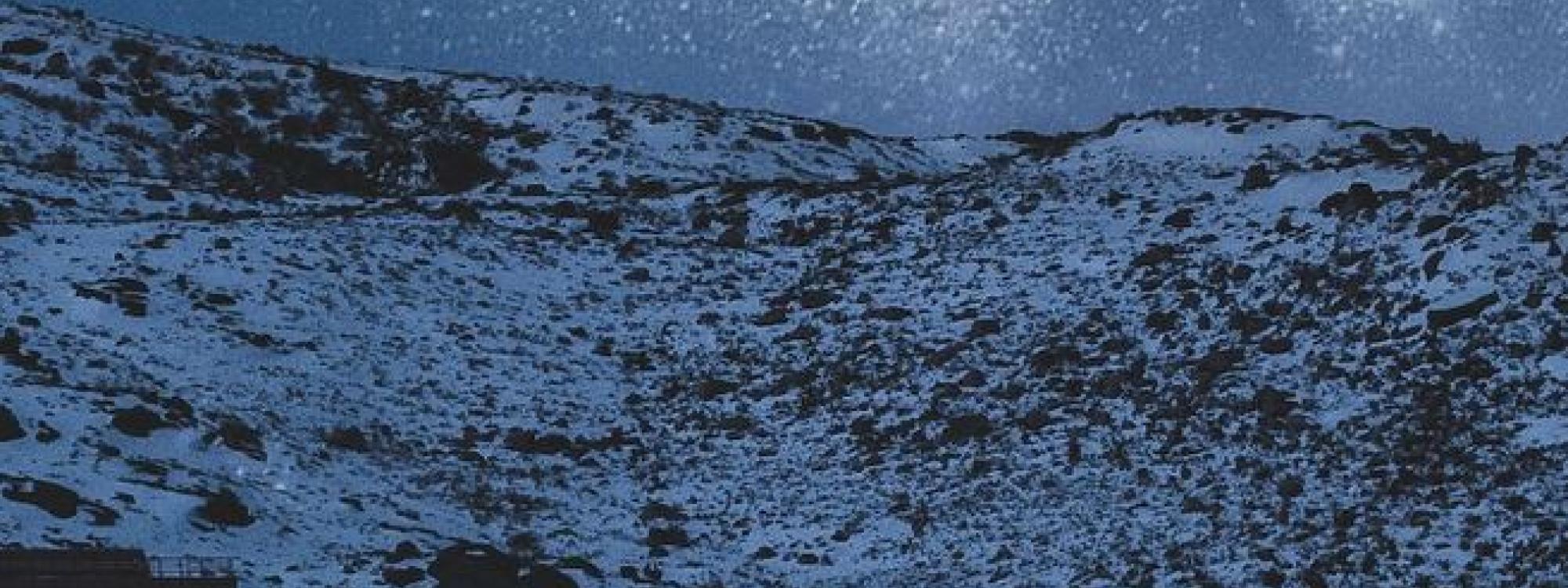 Snowy mountain scene at night